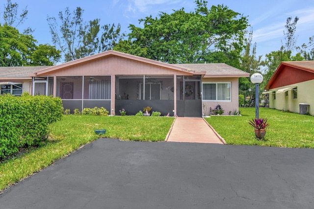 single story home with a sunroom and a front lawn