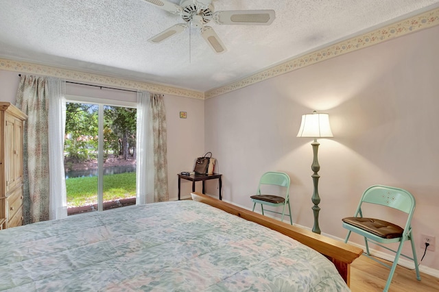 bedroom with wood-type flooring, a textured ceiling, ceiling fan, and access to exterior