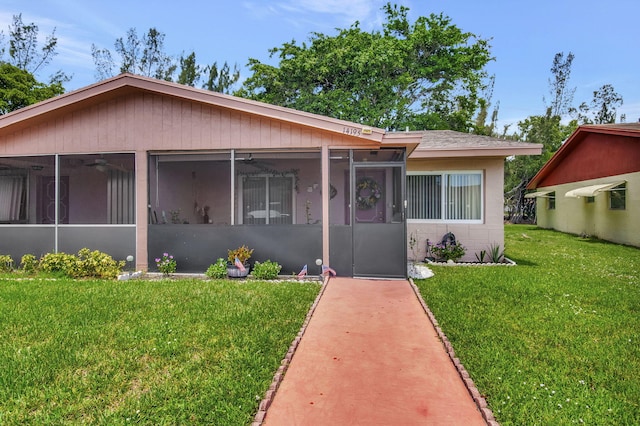 view of front of property with a sunroom and a front lawn