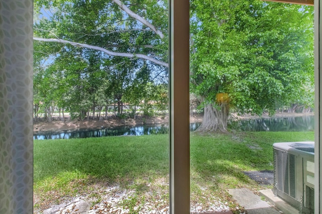 view of yard featuring a water view and central air condition unit