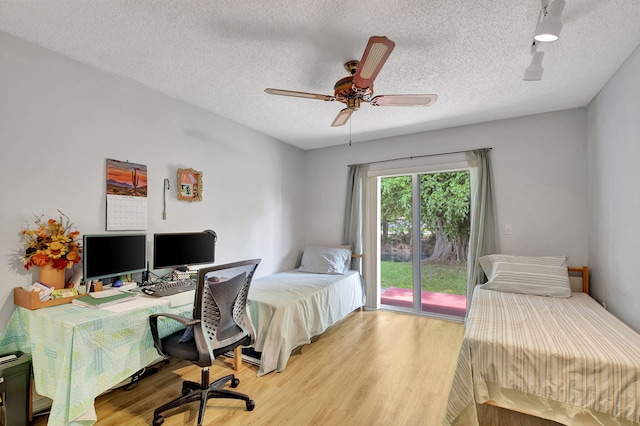 bedroom with light wood-type flooring, access to exterior, a textured ceiling, and ceiling fan