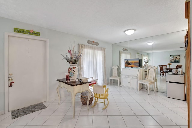 dining area with a textured ceiling and light tile patterned floors