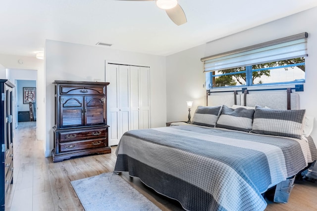 bedroom with a closet, light wood-type flooring, and ceiling fan