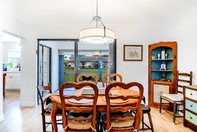 dining room featuring sink and light hardwood / wood-style flooring