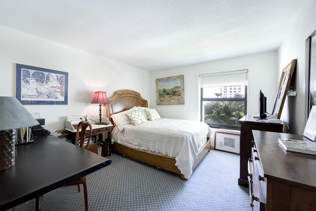 bedroom featuring a textured ceiling and light colored carpet