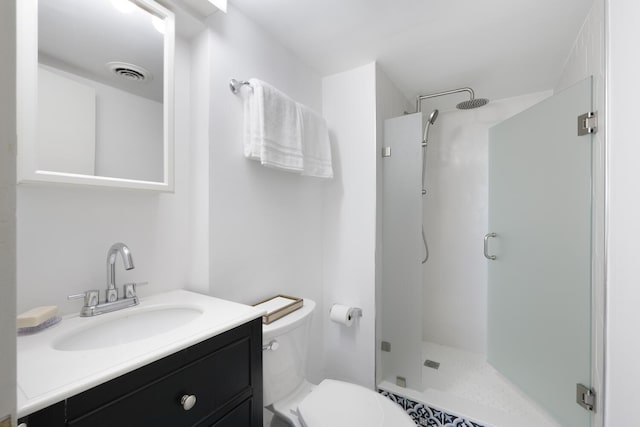 bathroom featuring vanity, toilet, and a shower with door