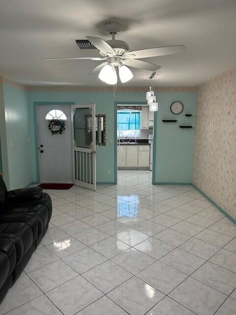 tiled living room featuring ceiling fan