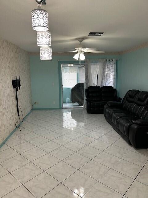 living room with light tile patterned floors and ceiling fan