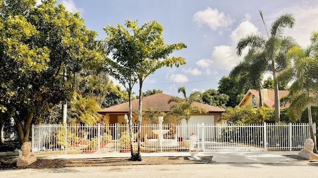 ranch-style home with an attached garage, a gate, fence, and concrete driveway