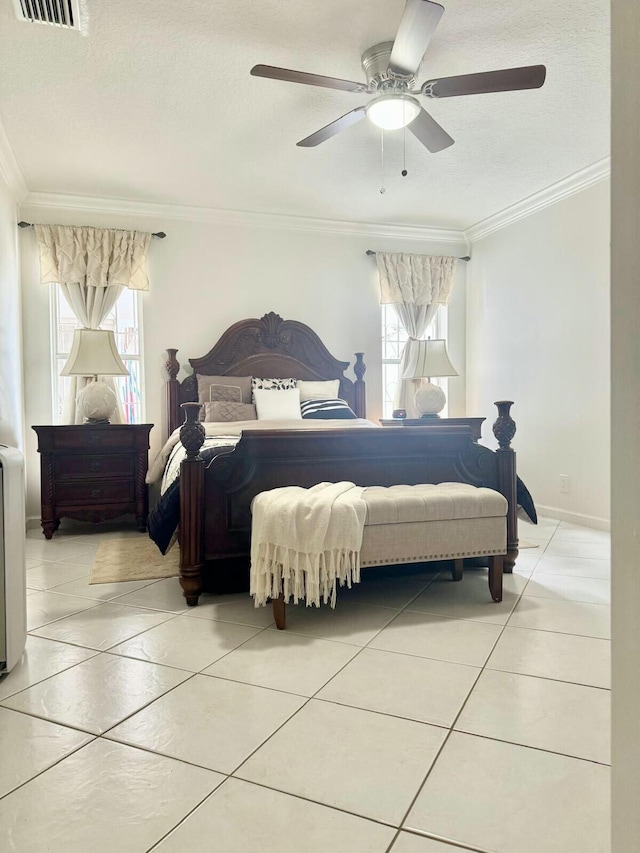 bedroom with light tile patterned floors, ornamental molding, a ceiling fan, and baseboards