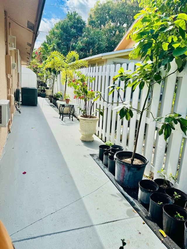 view of patio with fence and cooling unit