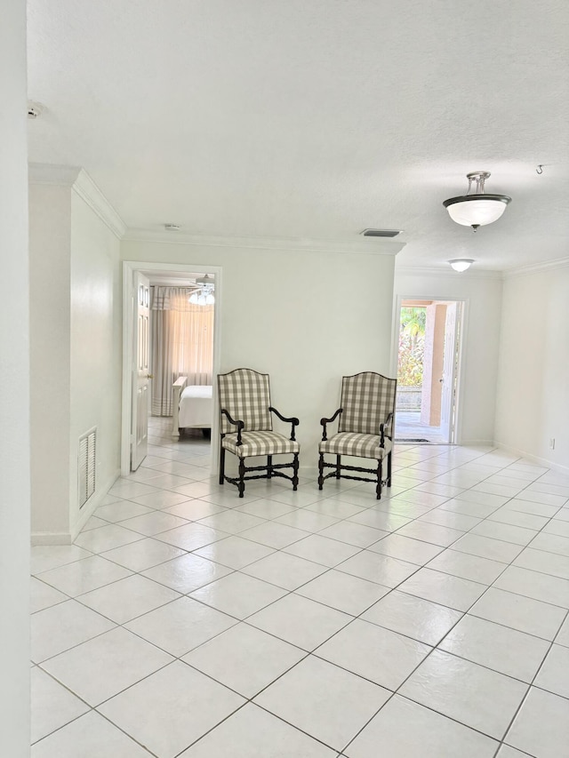 living area with baseboards, visible vents, crown molding, and light tile patterned flooring