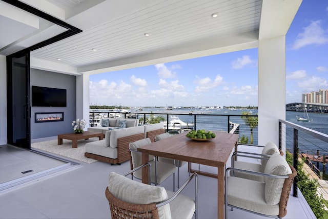 balcony with an outdoor hangout area and a water view