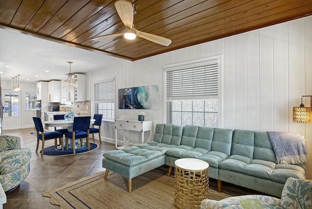 living area featuring a wealth of natural light, wooden ceiling, and dark tile patterned floors