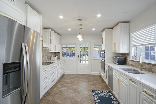 kitchen featuring backsplash, sink, stainless steel appliances, and white cabinetry