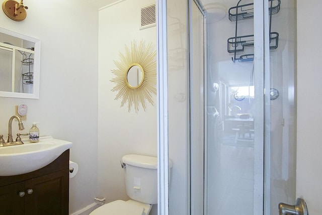 bathroom featuring a shower with shower door, toilet, and vanity