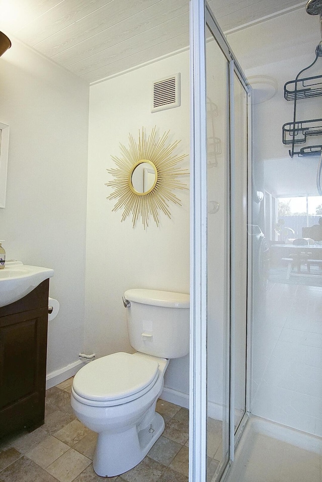 bathroom with a shower with shower door, vanity, and toilet