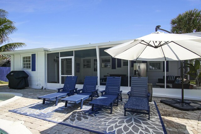 rear view of house with a patio and a sunroom