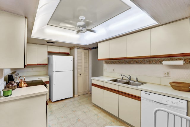 kitchen featuring ceiling fan, sink, white appliances, a tray ceiling, and white cabinets