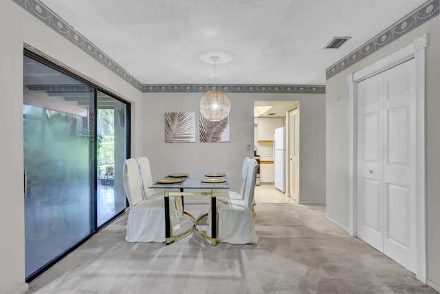 dining room with light carpet and a textured ceiling