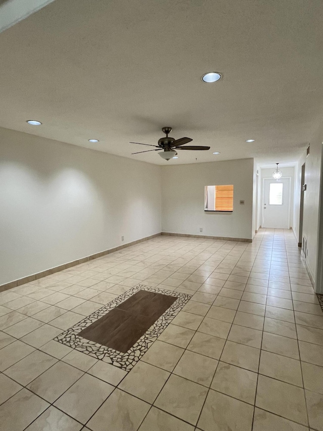 unfurnished room with light tile patterned floors and ceiling fan