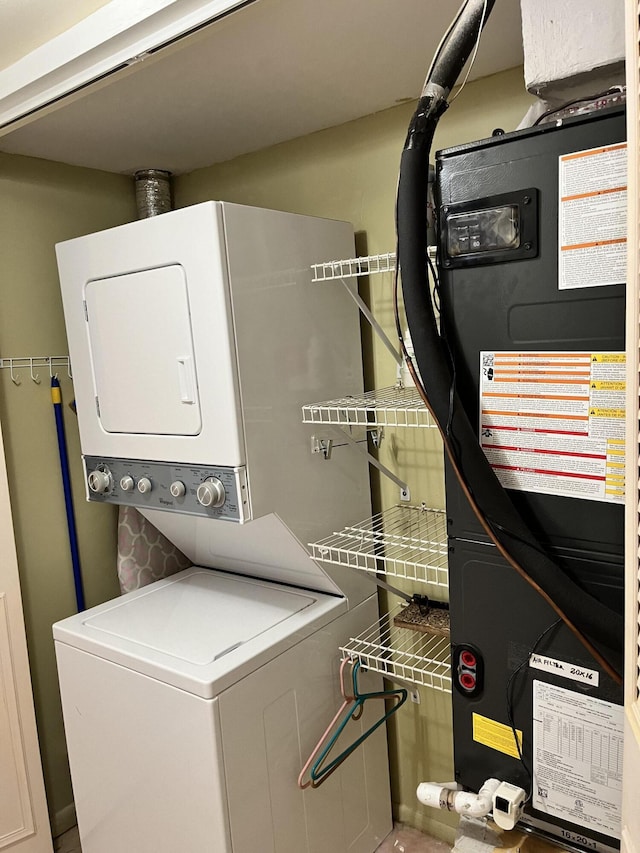 laundry room with stacked washing maching and dryer and heating unit