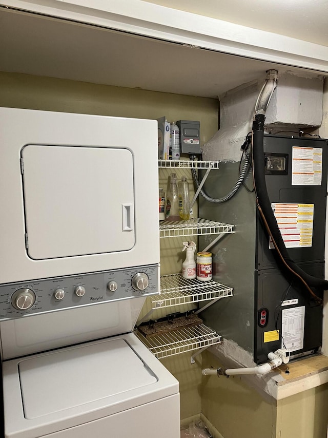 clothes washing area with stacked washer and dryer