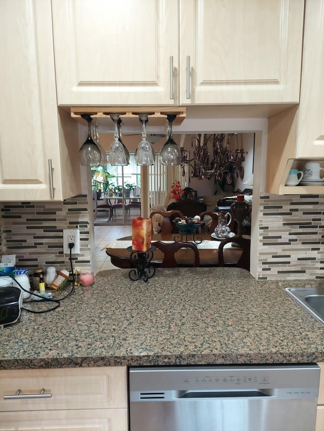 kitchen featuring stone counters, stainless steel dishwasher, and backsplash