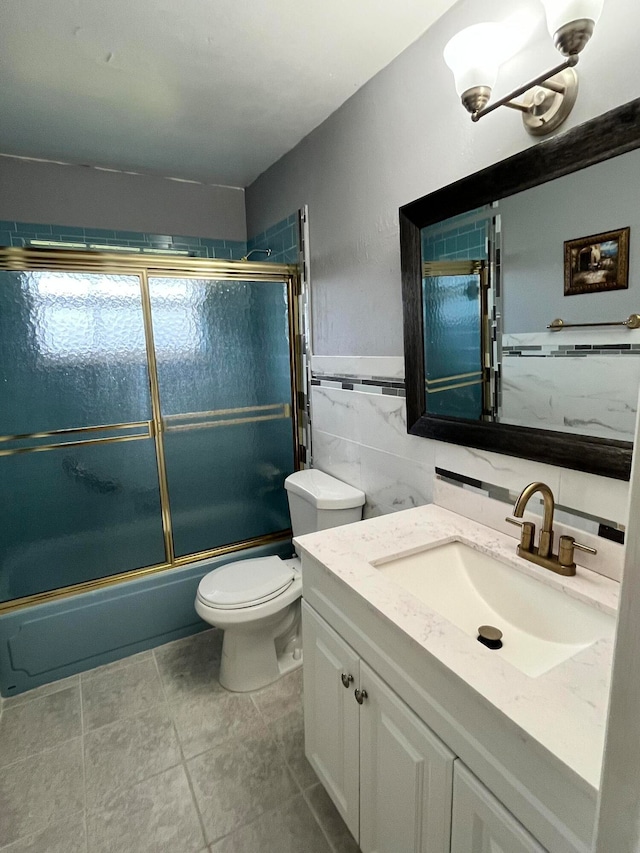 full bathroom with enclosed tub / shower combo, tile walls, tile patterned floors, toilet, and vanity