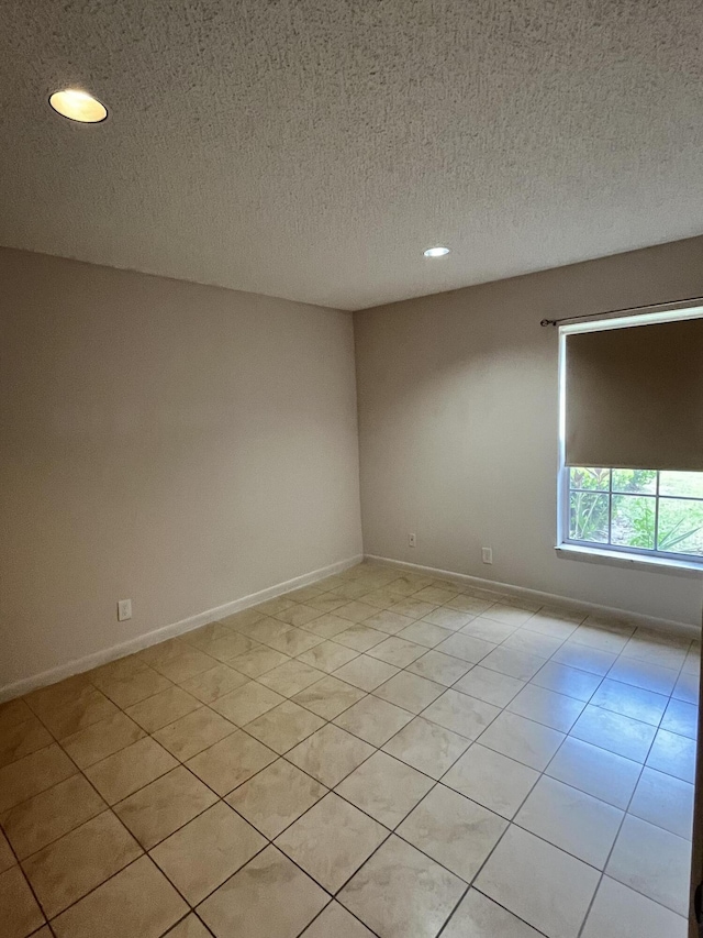 tiled spare room with a textured ceiling