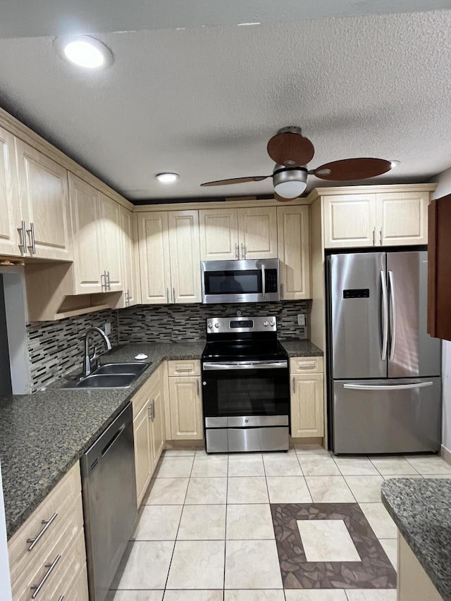 kitchen featuring ceiling fan, appliances with stainless steel finishes, sink, and decorative backsplash