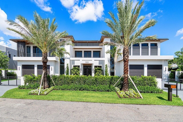 view of front of home with a balcony and a front lawn