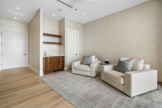 living area with sink and light wood-type flooring