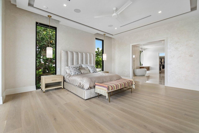 bedroom with multiple windows, light hardwood / wood-style flooring, and ceiling fan