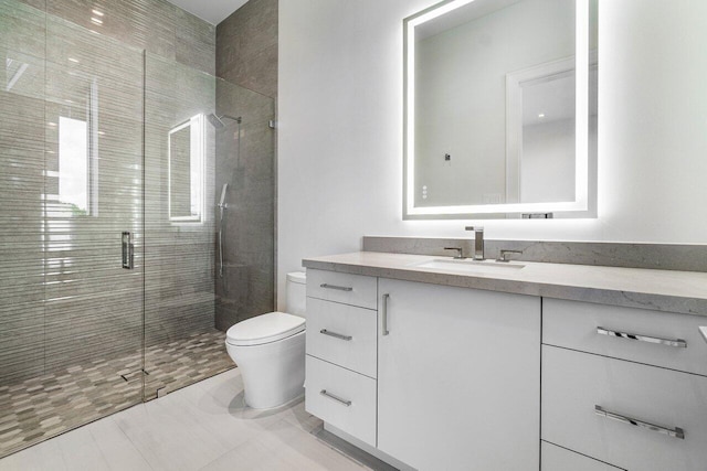 bathroom featuring vanity, a shower with door, and toilet