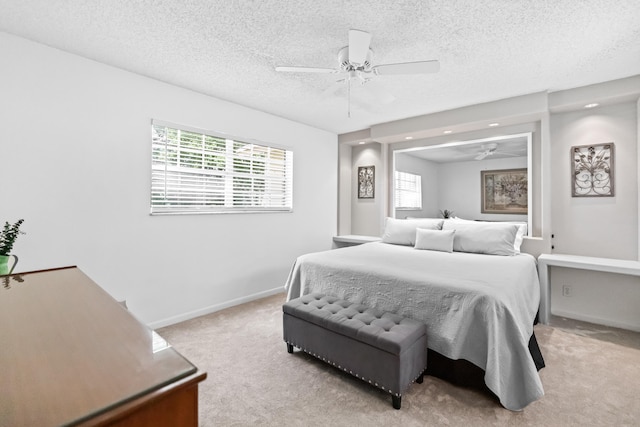 bedroom featuring ceiling fan, light colored carpet, and a textured ceiling