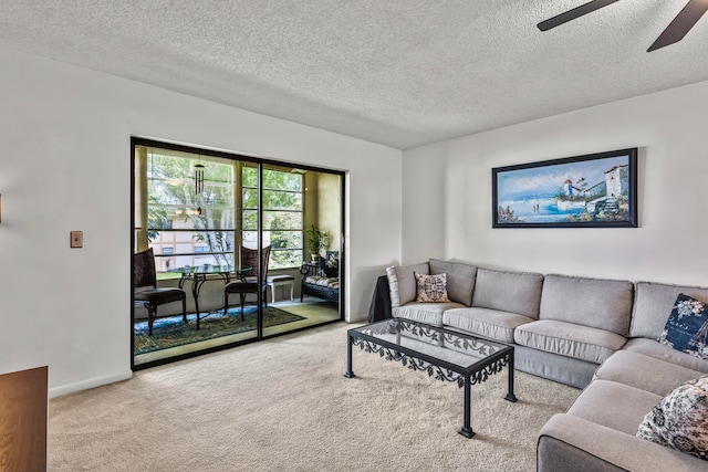 living room featuring a textured ceiling, light carpet, and ceiling fan