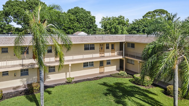 exterior space with a balcony and a yard