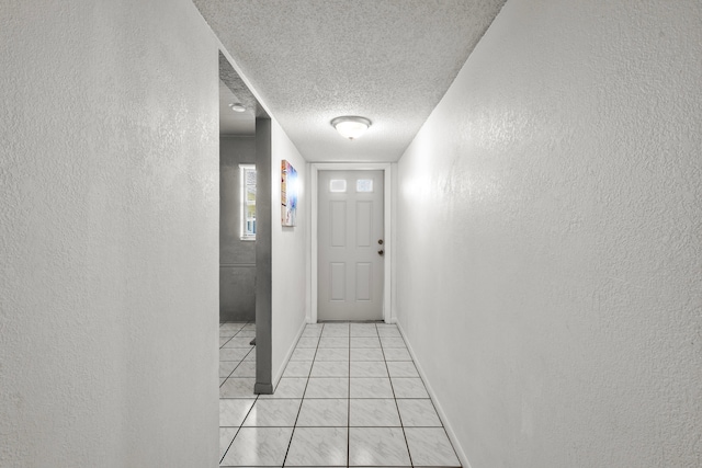 hall featuring a textured ceiling and light tile patterned floors