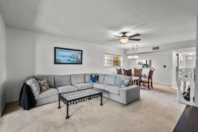 carpeted dining area featuring a textured ceiling, ceiling fan with notable chandelier, and plenty of natural light