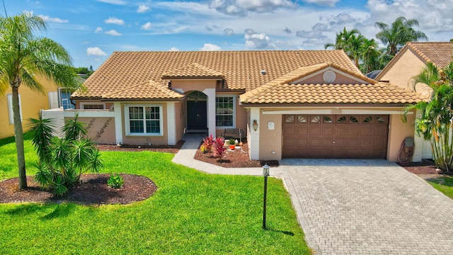 mediterranean / spanish-style home featuring a garage and a front lawn