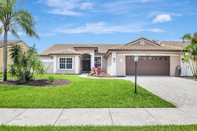 mediterranean / spanish-style home featuring a garage and a front yard