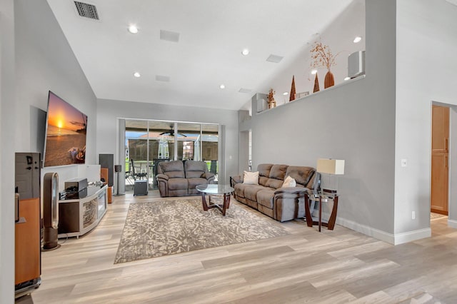 living room with ceiling fan, high vaulted ceiling, and light hardwood / wood-style flooring