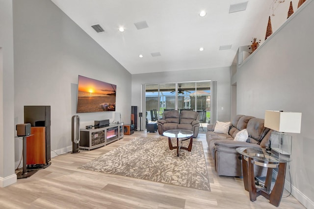 living room featuring ceiling fan, high vaulted ceiling, and light hardwood / wood-style floors