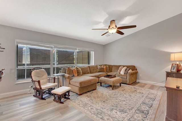 living room featuring lofted ceiling, ceiling fan, and light hardwood / wood-style flooring