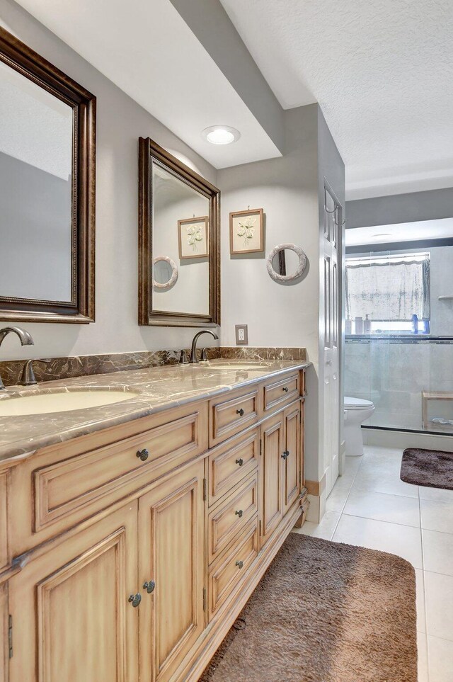 bathroom with vanity, tile patterned floors, toilet, and walk in shower