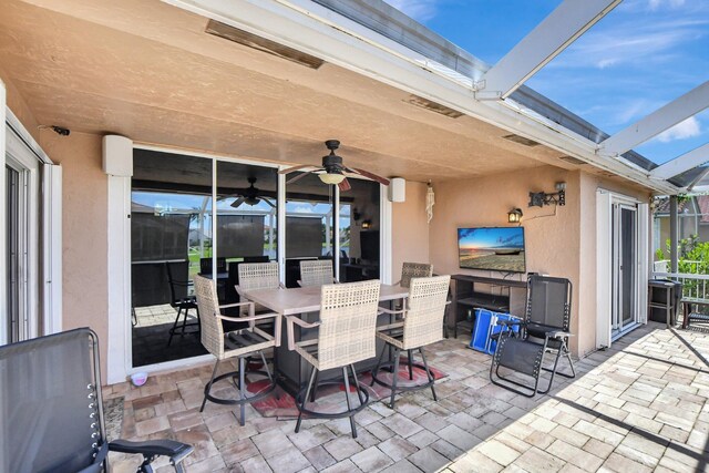 view of patio / terrace with ceiling fan and a lanai