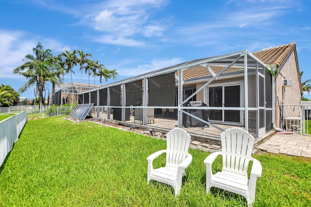 rear view of house with a patio area and glass enclosure