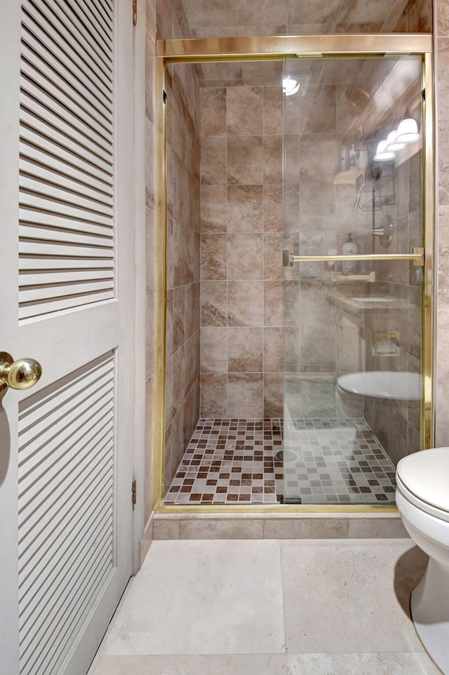 bathroom with toilet and an enclosed shower