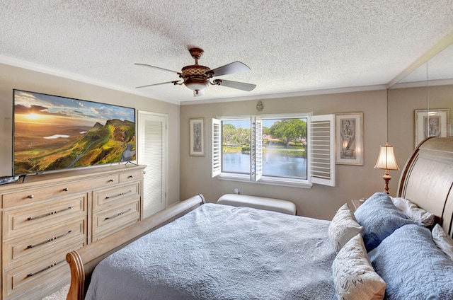 bedroom featuring ceiling fan, a textured ceiling, and ornamental molding